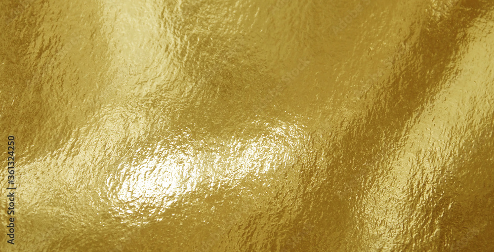 Fototapeta premium Gold foil texture background with highlights and uneven surface
