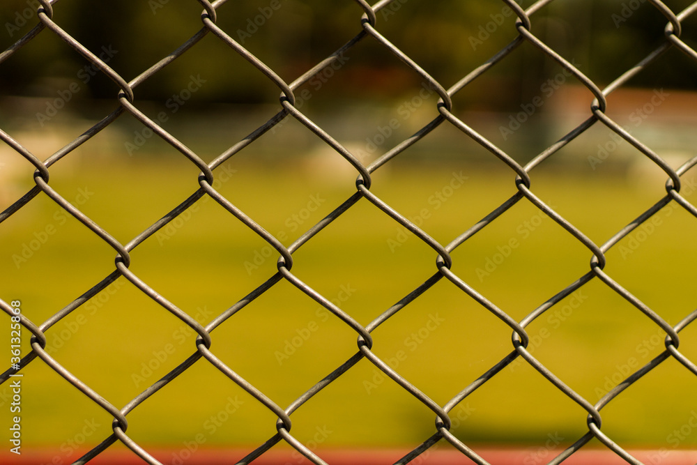 Fototapeta premium chain link fence around a green public park