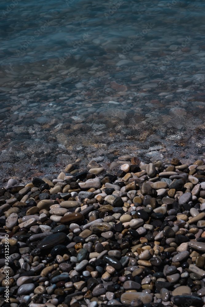 A wave rolls over the rocky shore. Pebble beach. Seashore. A wave rolls over the rocky shore. Pebble beach. Seashore.