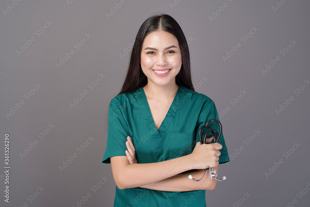a female doctor wearing a green scrubs and stethoscope is on grey background studio a female doctor wearing a green scrubs and stethoscope is on grey background studio