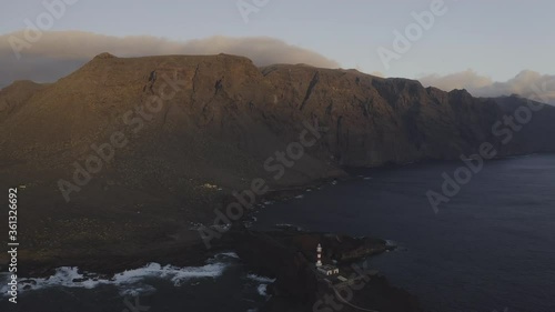 Sunset fly above Tenerife lighthouse Punta Teno west point mountains ocean waves with drone
