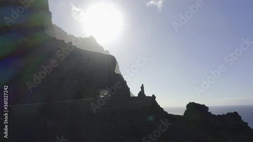 Sun flares ocean shore mountains and cliffs with drone