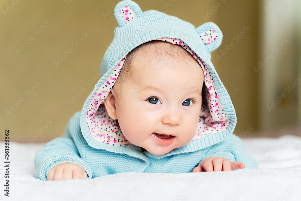 a beautiful newborn blue eyed girl lies on her tummy and smiles a beautiful newborn blue eyed girl lies on her tummy and smiles