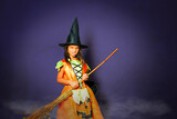 Halloween witch spooky girl portrait with broom over dark background