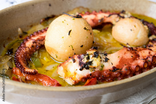 Traditional portuguese dish popular on Madeira island - polvo a lagareiro, octopus with baked potatoes and olive oil. photo