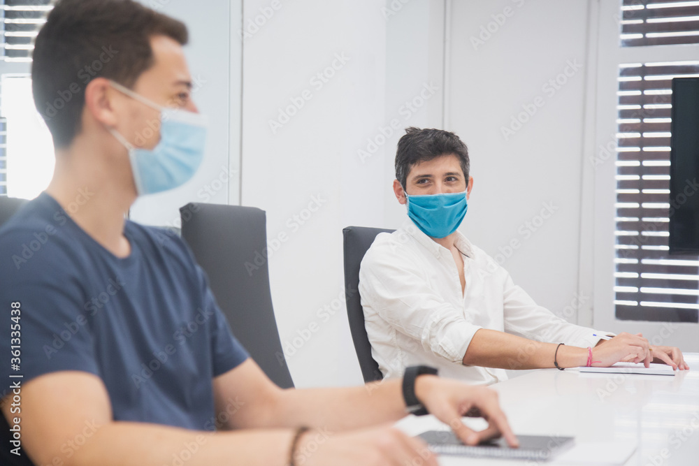 people working in an office during coronavirus or covid-19, with markings and maintaining social distance. Business meeting in the new normal people working in an office during coronavirus or covid-19, with markings and maintaining social distance. Business meeting in the new normal