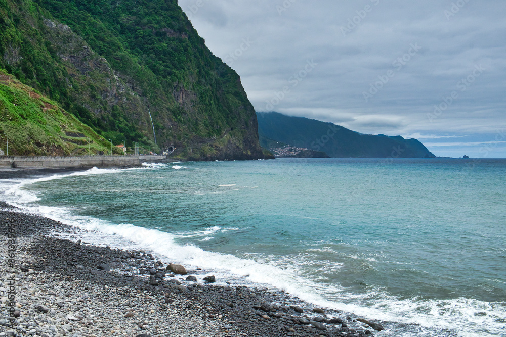 An ocean tide on the pebble beach of Madeira island An ocean tide on the pebble beach of Madeira island