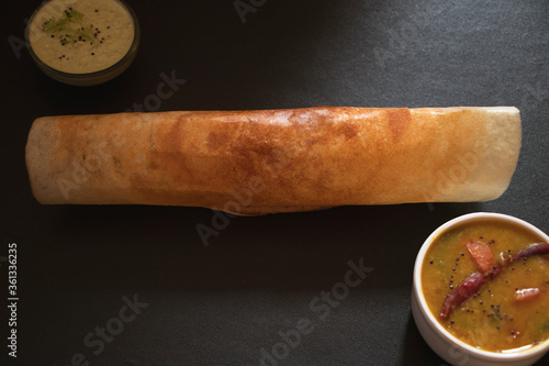 A dosa , originating from South India, made from a fermented rice and lentil served with sambar and coconut chutney