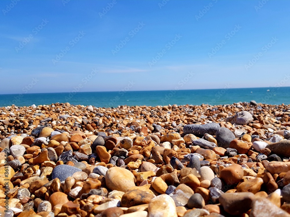 Beautiful beach landscape with colorful stones and blue sky. Sea peblles beach. Beautiful nature. Beautiful beach landscape with colorful stones and blue sky. Sea peblles beach. Beautiful nature.