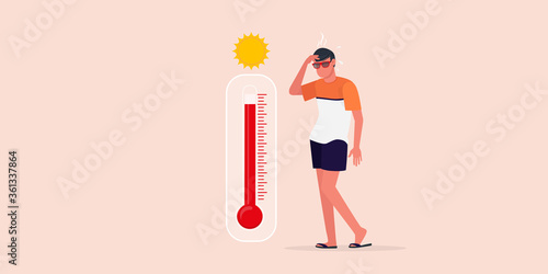 The guy is standing on the beach near the thermometer, he is very hot