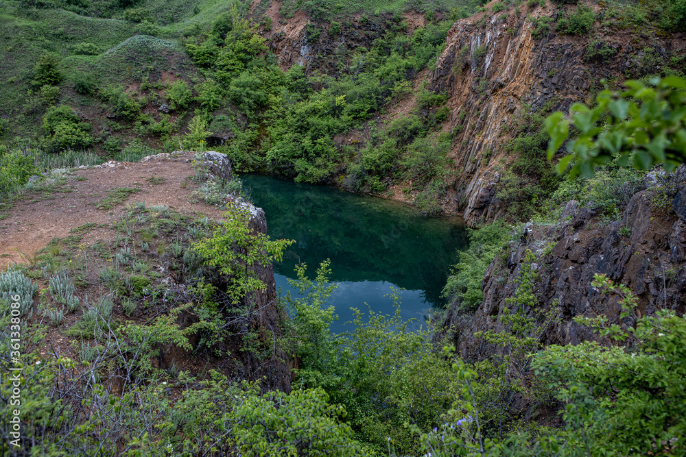 Old flooded rock quarry lake with clean transparent water