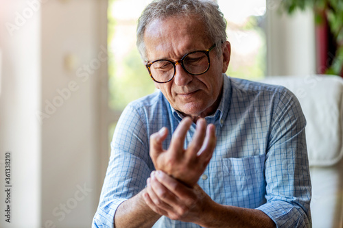 Senior man with arthritis rubbing hands
