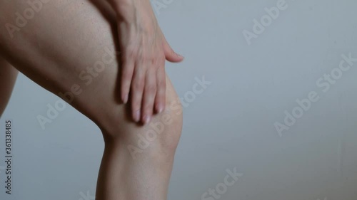 Woman applying cream to her knee, close up