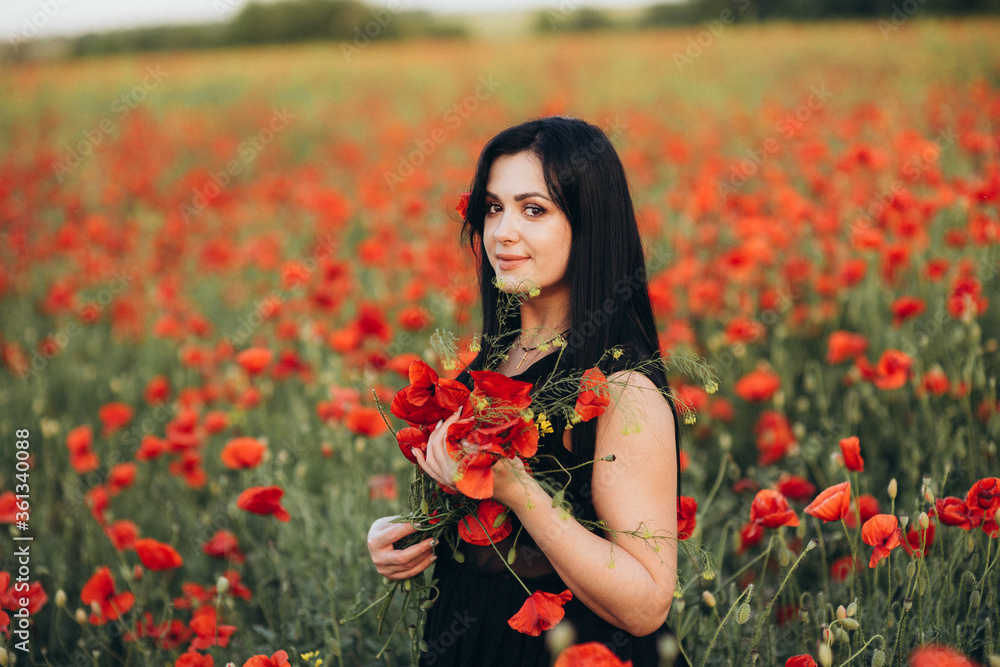 Portrait of a beautiful cute brunette girl in poppy field at sunset Portrait of a beautiful cute brunette girl in poppy field at sunset