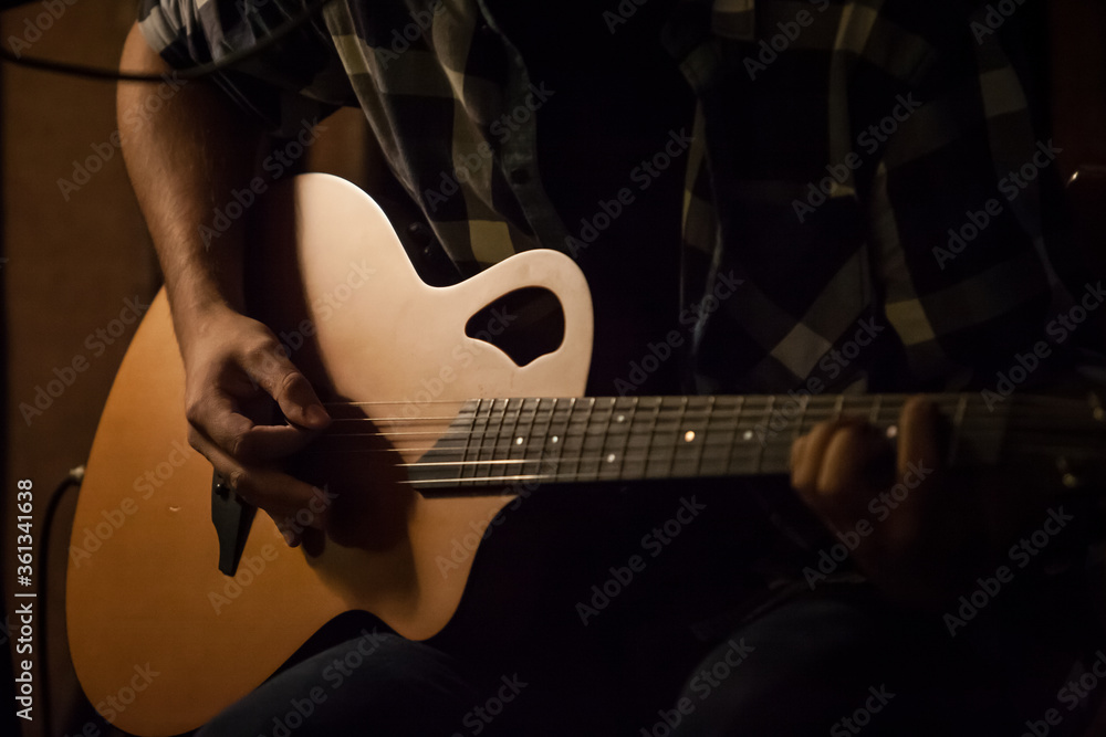 Fototapeta premium Boy paling guitar in the warm evening light