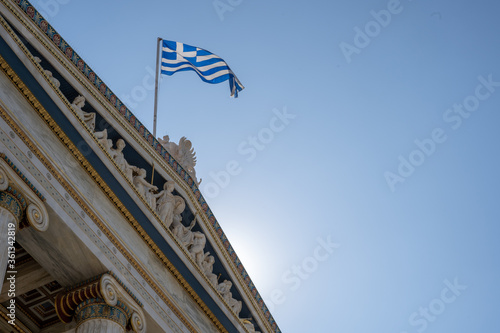 Greek flag flying over classic-styled building in Athens