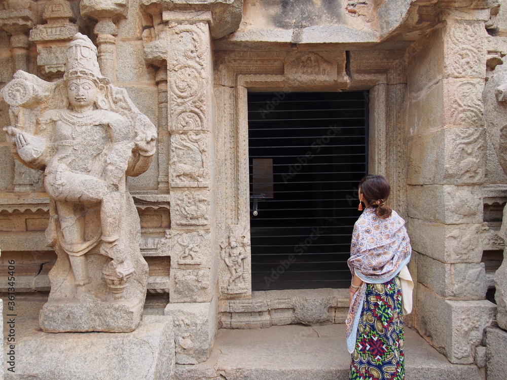 A woman strolls around inside a historic ruins, The Ruins of Hampi, Hampi, Karnataka, South India, India