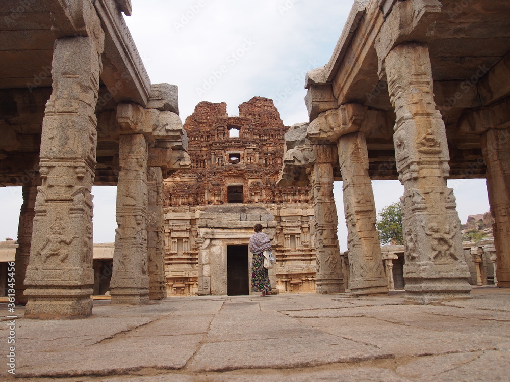 A woman strolls around inside a historic ruins, The Ruins of Hampi, Hampi, Karnataka, South India, India