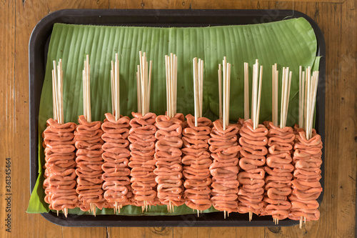 Uncooked Isaw or chicken intestine on sticks ready to be barbecued. Isaw is a Filipino delicacy. photo