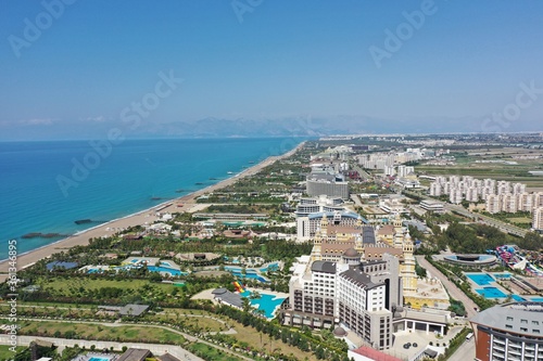Fototapeta Naklejka Na Ścianę i Meble -  Sandy beaches of the Mediterranean. Kundu holiday complex with five star hotels. Beach, sea, water sports, parasailing, entertainment and shopping center. Aerial view with drone. Kundu, Lara -TURKEY