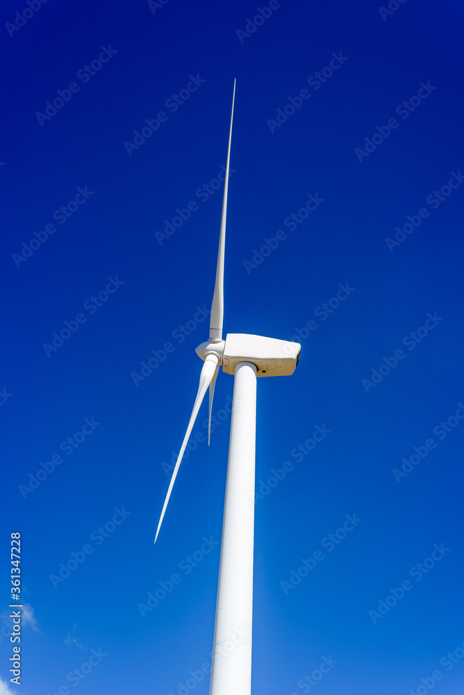 Wind turbines generating electricity on hill against blue sky with white clouds. Concept eco clean energy production, renewable energy Wind turbines generating electricity on hill against blue sky with white clouds. Concept eco clean energy production, renewable energy