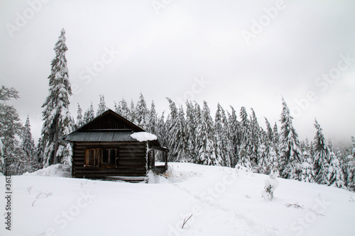 Snow-covered forester's house during bad winter weather