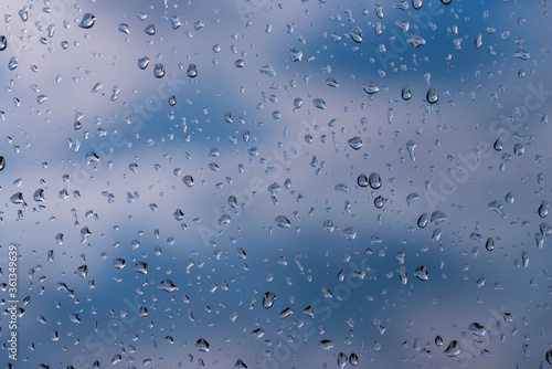 Szyba okienna pokryta kroplami deszczu.