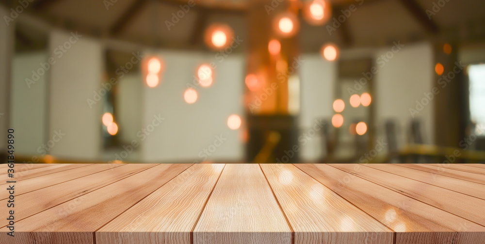 Empty wooden table top with lights bokeh on blur restaurant background	