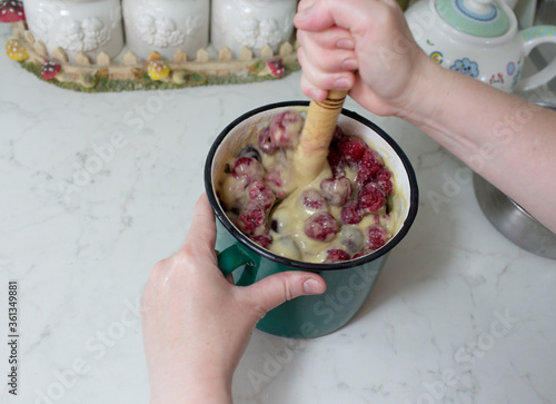 Preparation of cake with cherries and raspberries.