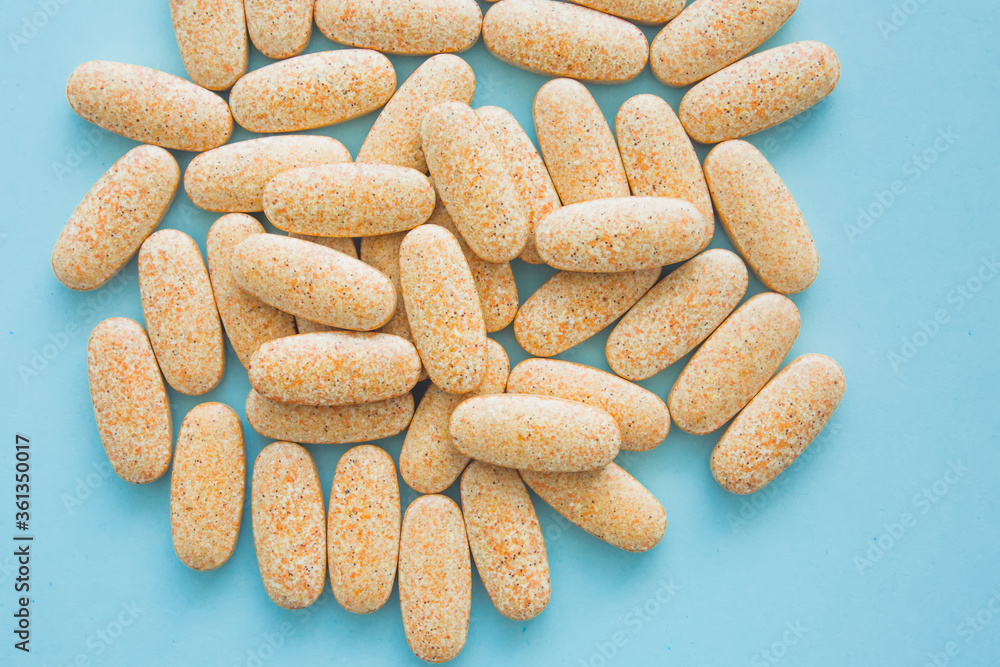 Health concept. Bright colored pills on blue background. Handful of drugs, treatment. Vitamins and dietary supplements. Health concept. Bright colored pills on blue background. Handful of drugs, treatment. Vitamins and dietary supplements.