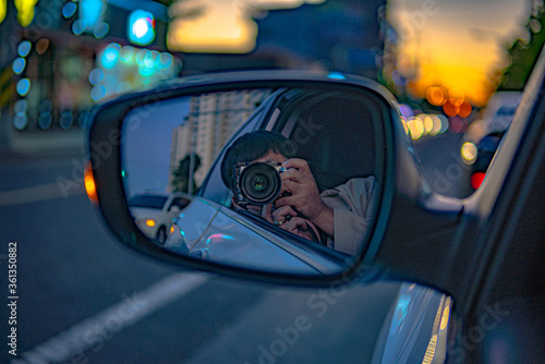 a photograph of a man taking a picture of himself in a side mirror.