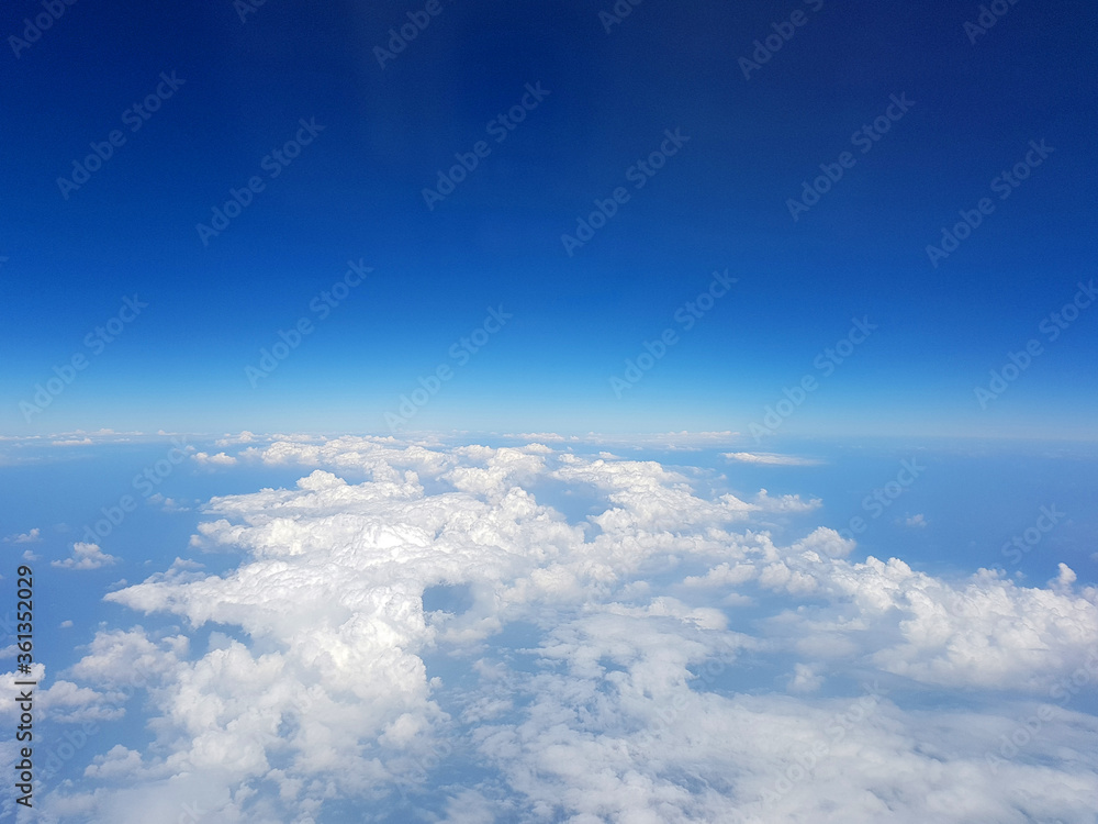 View on the blue sky with clouds from airplane window View on the blue sky with clouds from airplane window