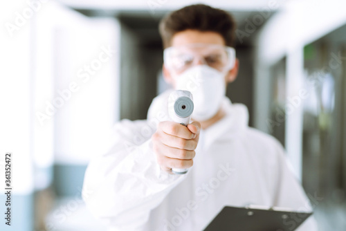 Disease control expert with an Infrared thermometer equipment to check the temperature. The concept of preventing the spread of the epidemic and treating coronavirus, pandemic in quarantine city. 