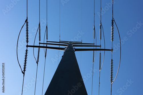 High Voltage Electric Power line on pole against bright blue sky