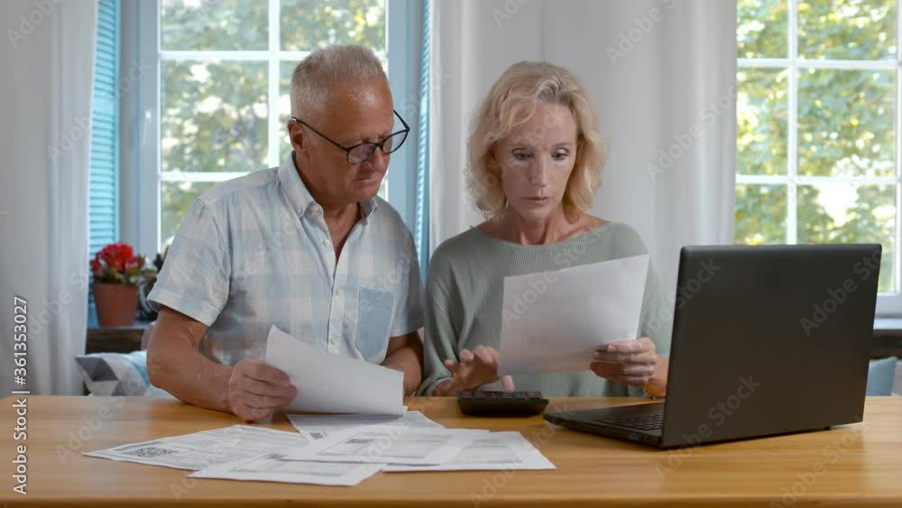 Mature couple sitting and managing expenses at home. Mature couple sitting and managing expenses at home.