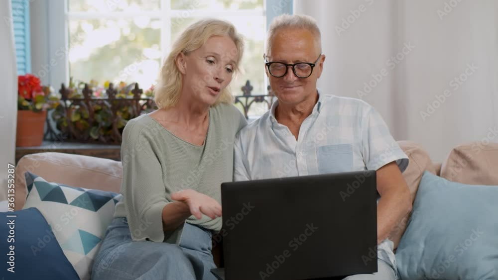Modern mature couple have fun using laptop at home Modern mature couple have fun using laptop at home