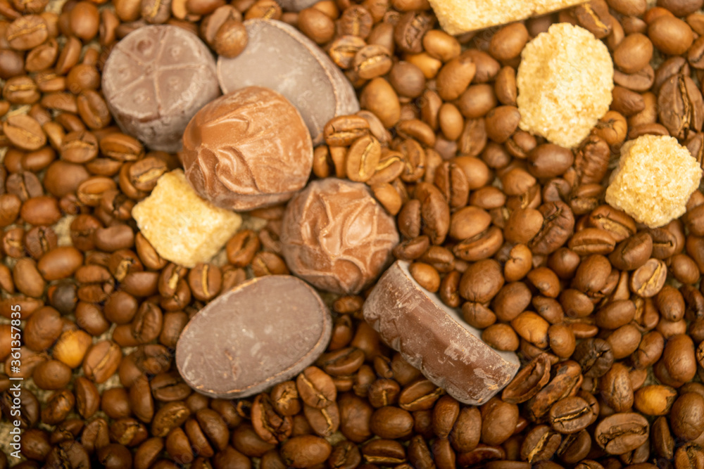 Chocolate, coffee beans, and chunks of brown cane sugar. Close up. Surface texture.