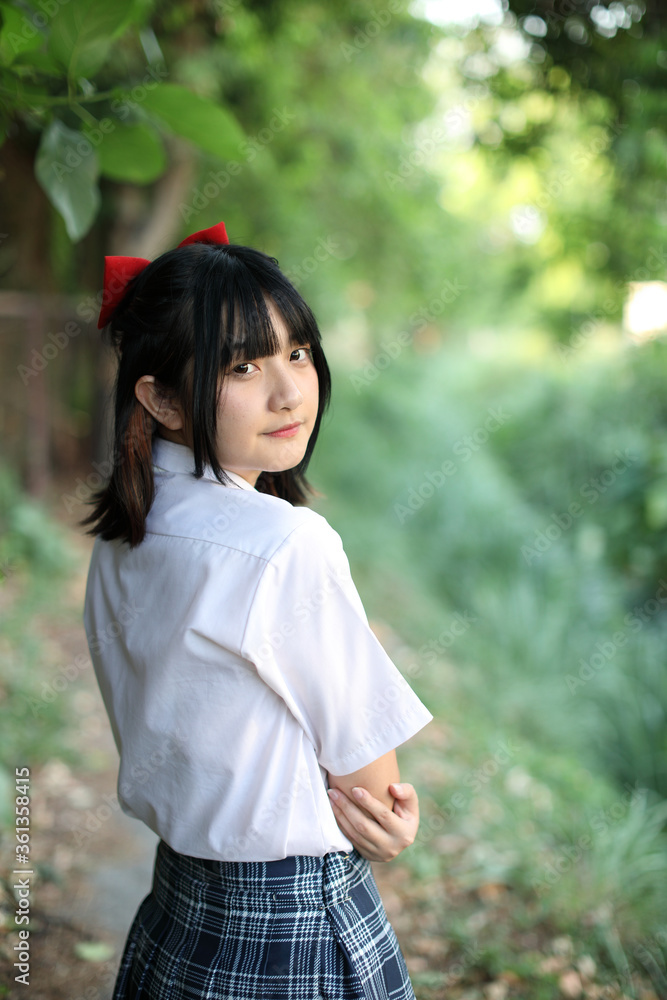 Asian school girl walking and looking in urban city with tree background Asian school girl walking and looking in urban city with tree background