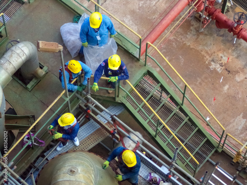 High building construction site with workers and steel bars.Group of workers working at high building construction site.and petrochemical plant