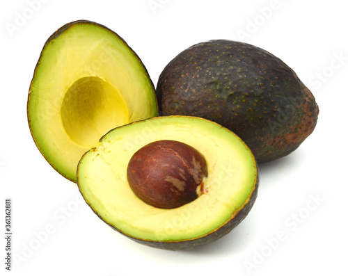 Whole and two half avocado isolated on white.