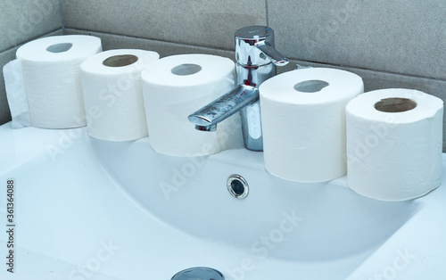 Lots of toilet paper rolls on a sink. Panic concept.