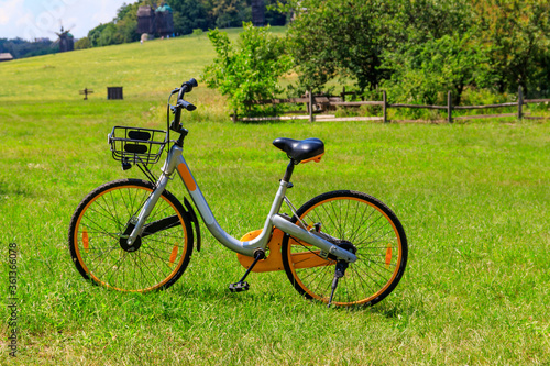 Modern bicycle parked on a green lawn in rural area