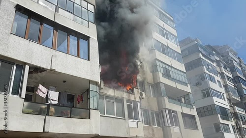 Arson or fire disaster - burning fire flame in habitable building wit apartments. Global warming heat.
