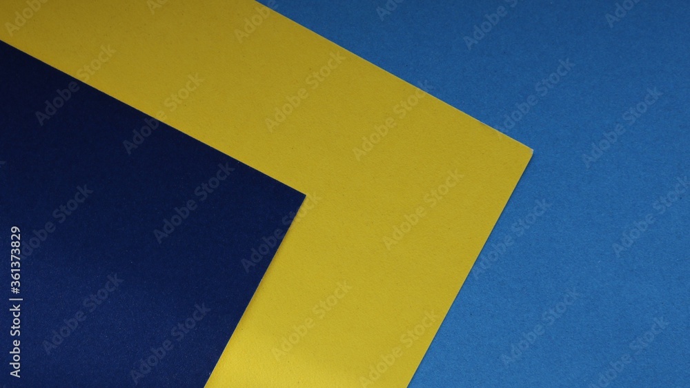 sheets of thick paper light blue, dark blue and yellow laid out in a unique combination with a synchronous arrangement of corners sheets of thick paper light blue, dark blue and yellow laid out in a unique combination with a synchronous arrangement of corners