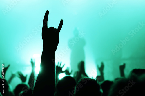 Obraz na płótnie hand with a goat sign of dancing punk from the crowd at a rock concert of a popular band w salonie
