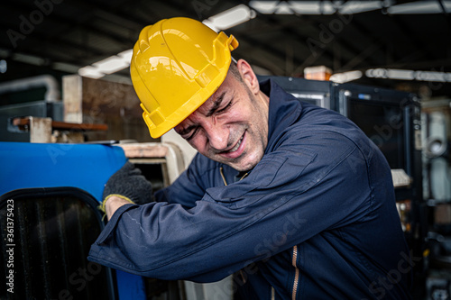Factory worker got his arm stuck in the machine. Workplace accident. occupational hazard.