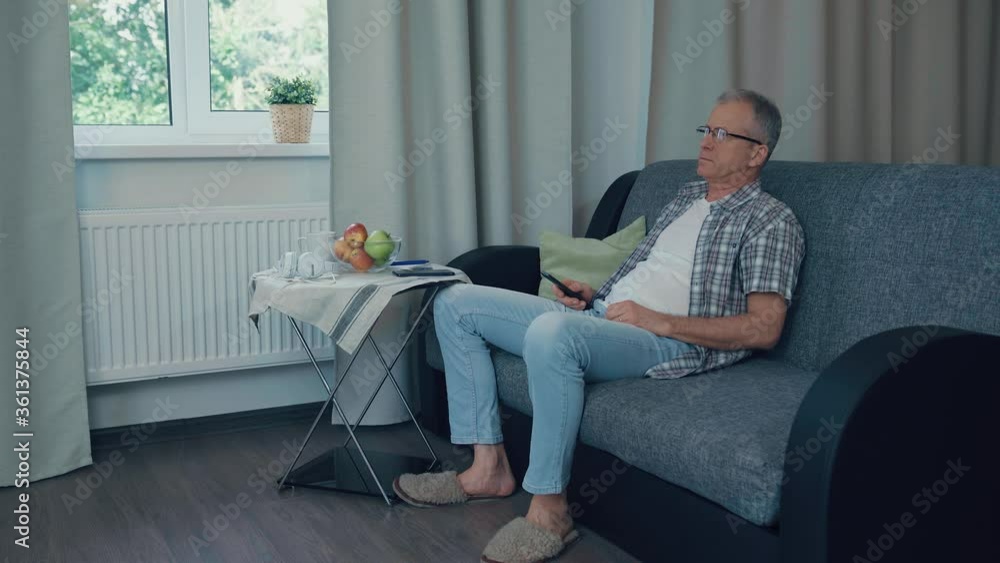 A man makes an online purchase in front of the TV. A man makes an online purchase in front of the TV.