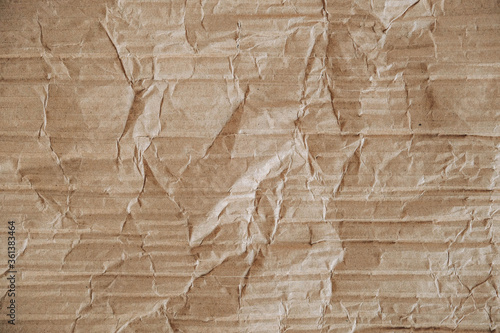 Crumpled corrugated cardboard surface texture background. Seamless crumpled brown paper textured backdrop. Top view. Copy, empty space for text