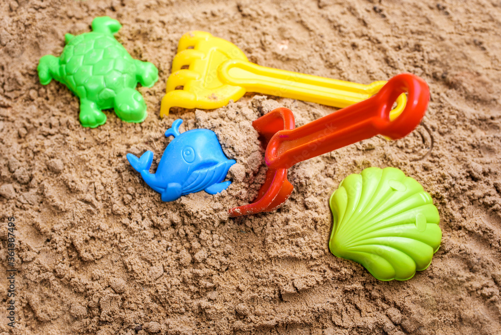 Beach sand with toys for the baby, water, the word summer in colored letters. Beach sand with toys for the baby, water, the word summer in colored letters.