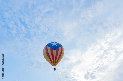 Globo aerostático con bandera independentista catalana  volando en un día nublado photo